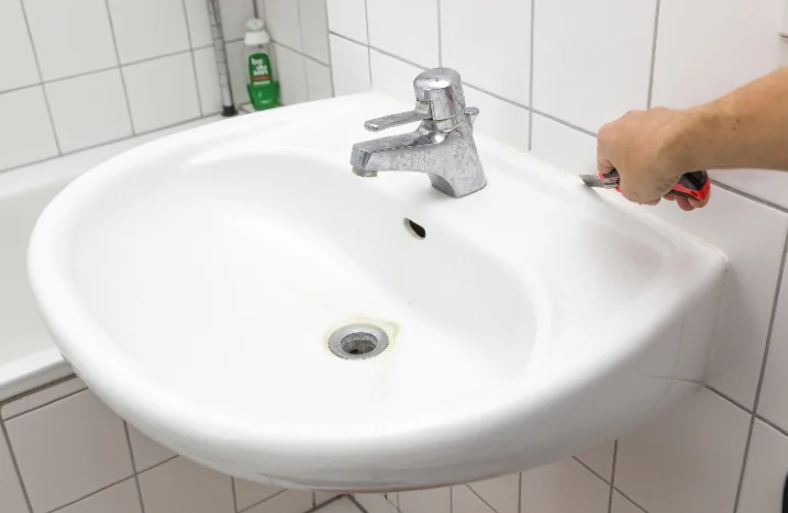 Person entfernt Silikonfuge